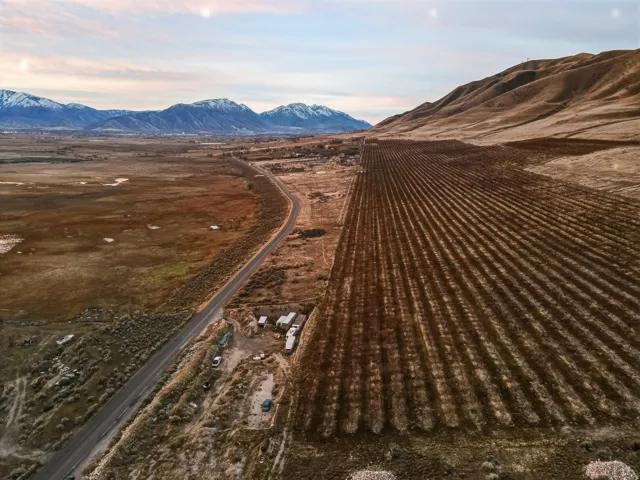 Aerial view of sparsely populated area with a mountainous background and extensive farmland