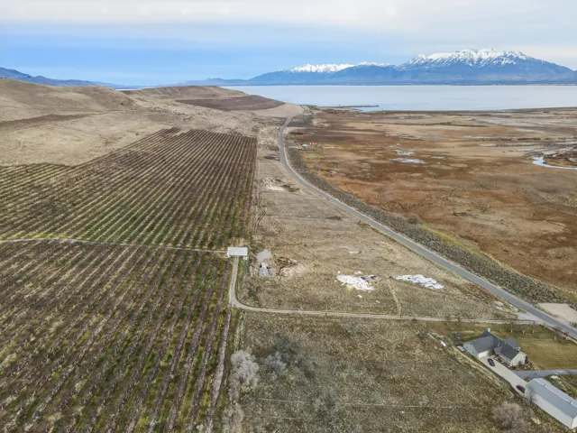 Aerial view of property and surrounding area featuring rural landscape, a mountainous background, and abundant farmland