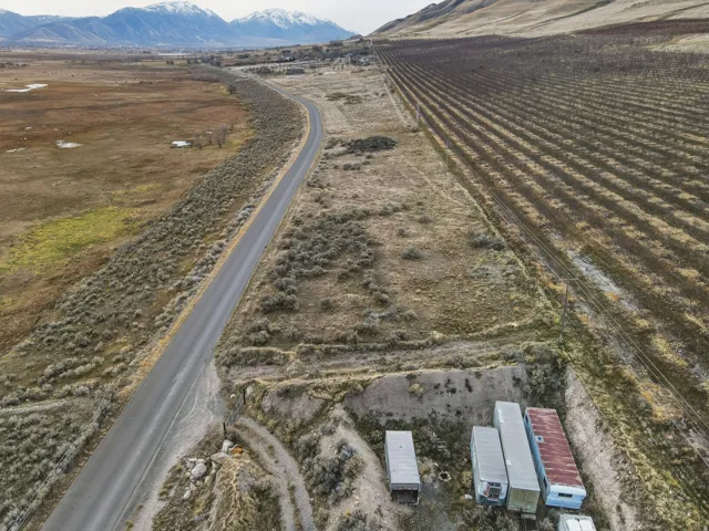 Aerial view of property's location featuring rural landscape, rows of crops, and a mountain backdrop