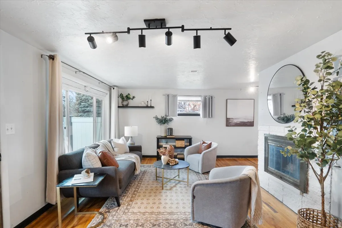 Cozy living room has large picture window and fireplace