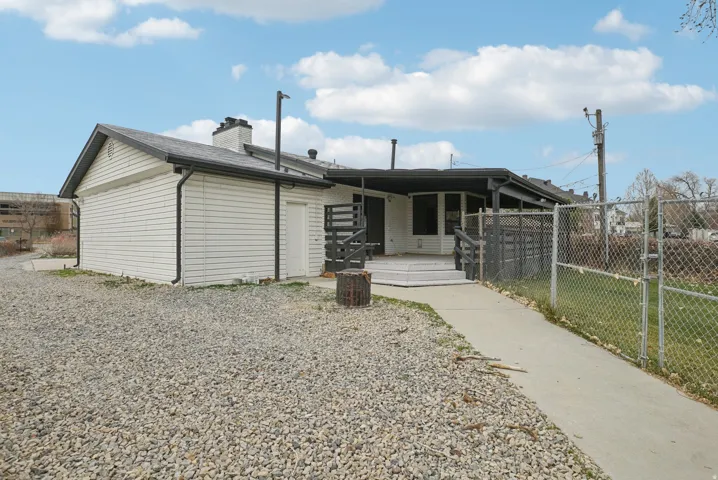 View of front facade with a gate and a chimney