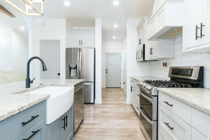 Kitchen featuring stainless steel appliances, light wood finished floors, white cabinetry, light stone countertops, and recessed lighting