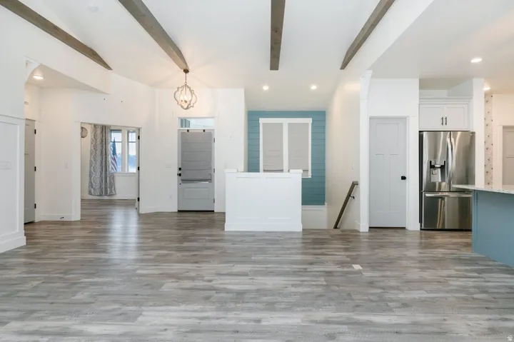 Living room featuring recessed lighting, beam ceiling, a chandelier, and dark wood-style floors