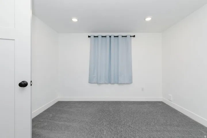 Bedroom with dark carpet and recessed lighting