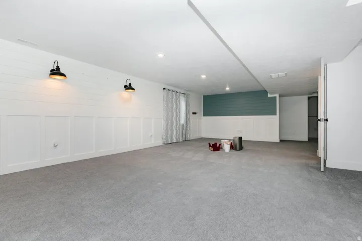 Family room with light carpet, recessed lighting, and wainscoting