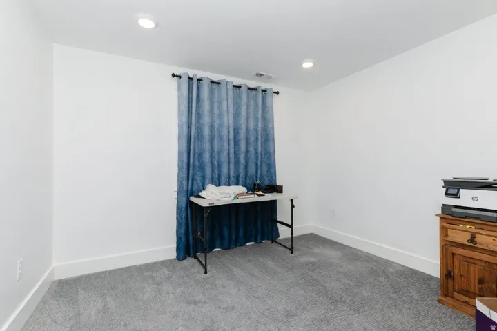 Carpeted bedroom with baseboards and recessed lighting