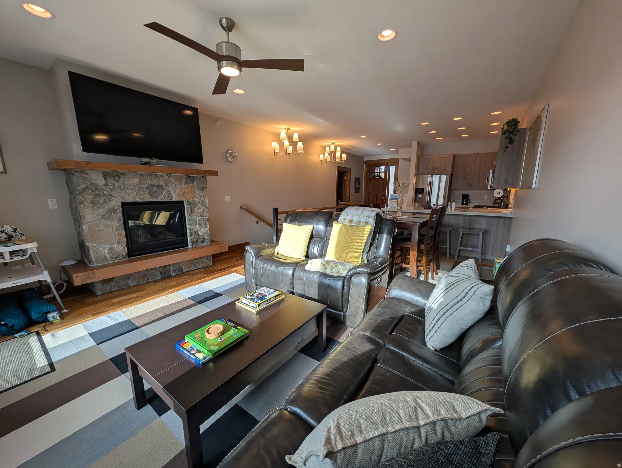 Living area featuring recessed lighting, a stone fireplace, wood finished floors, and ceiling fan