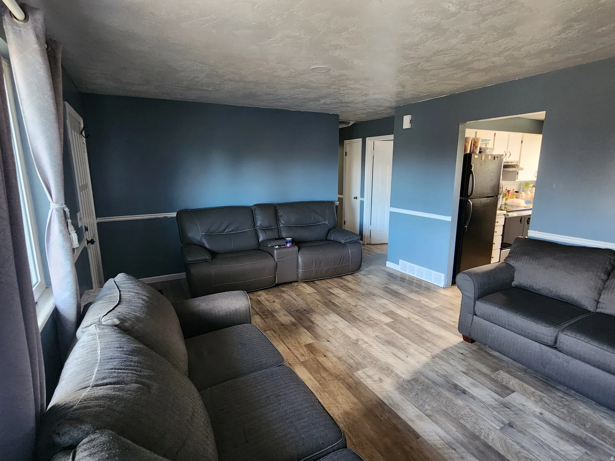 Living room with wood finished floors and a textured ceiling