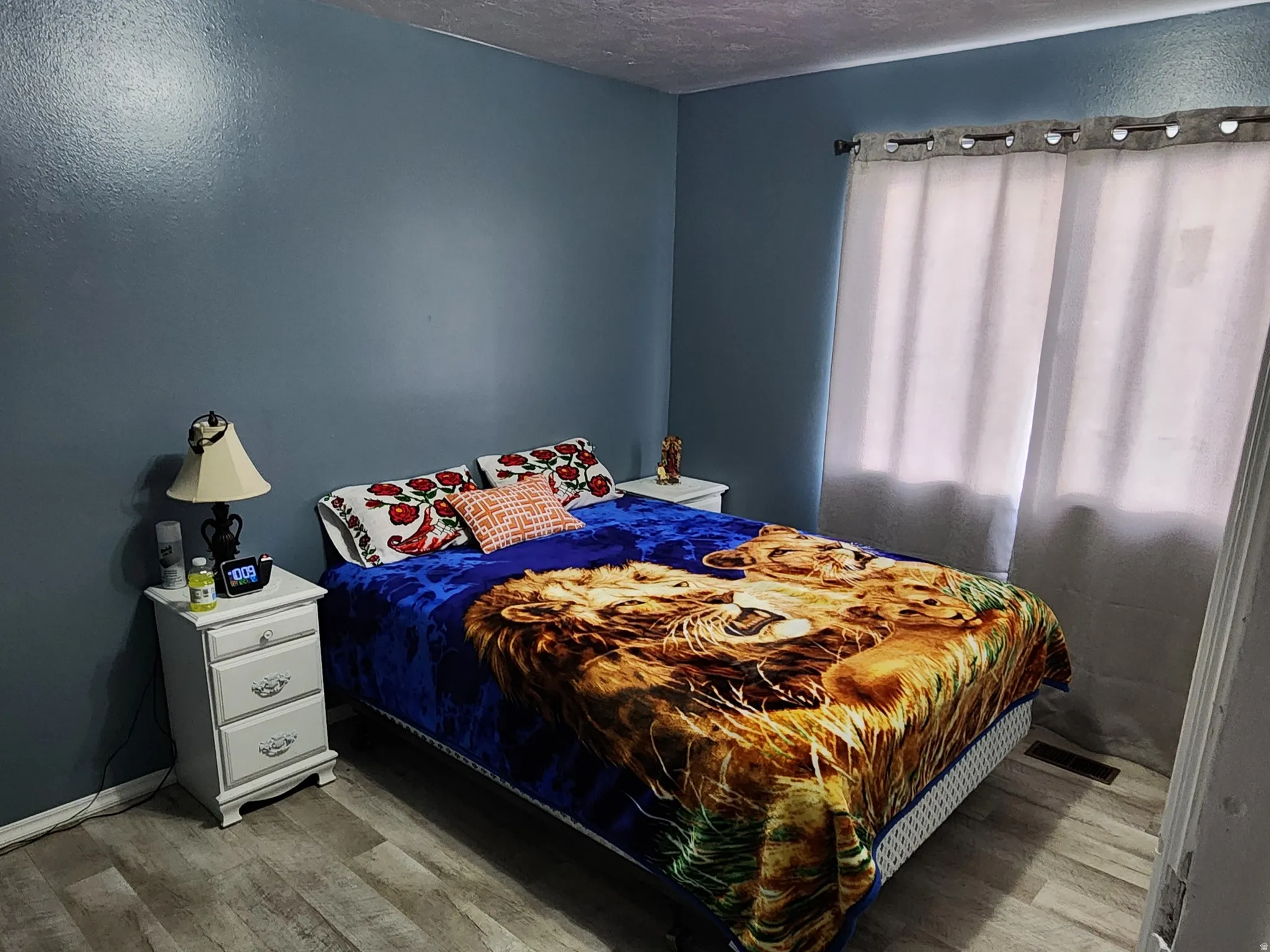 Bedroom with wood finished floors and a textured ceiling