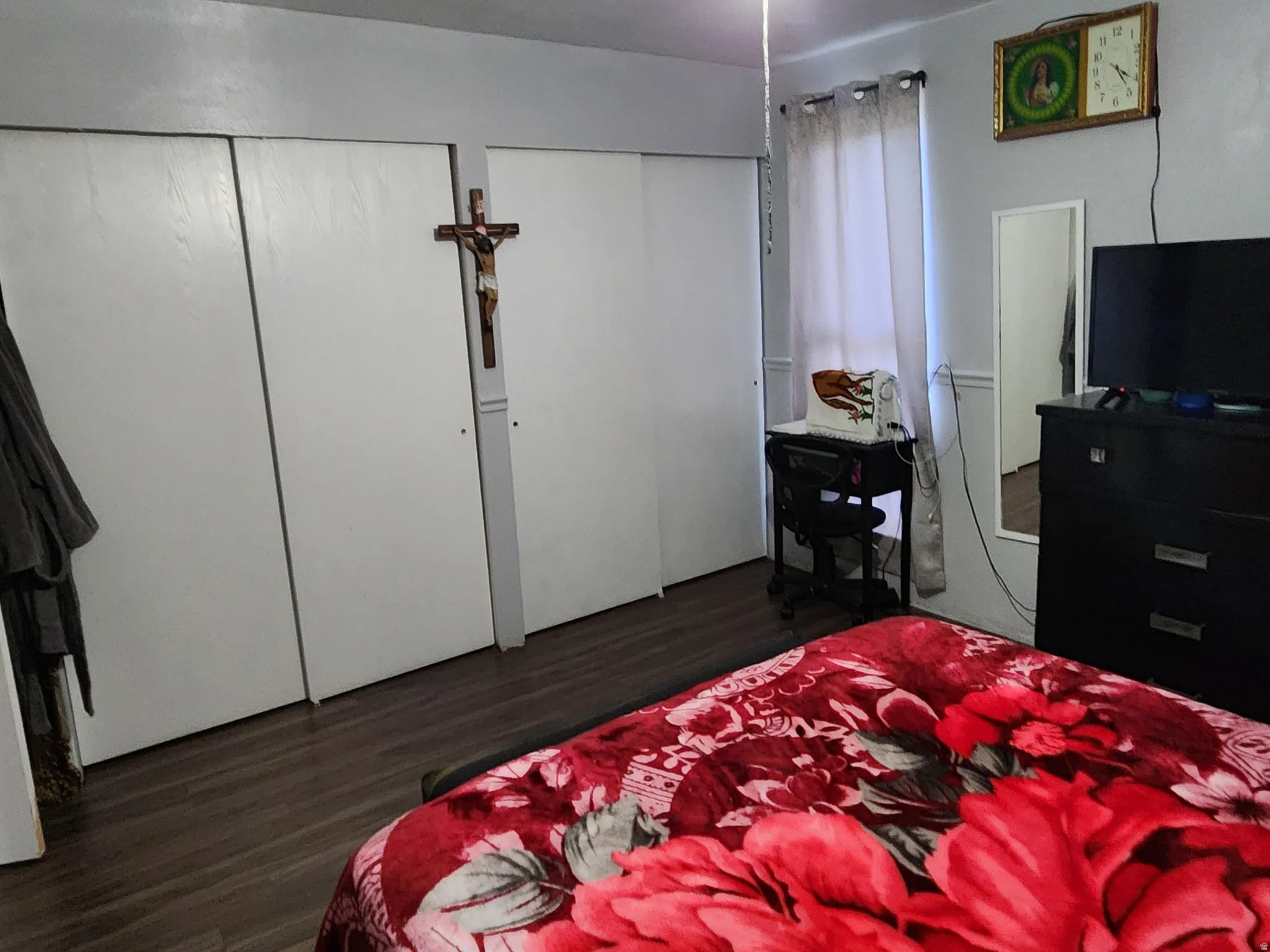Bedroom with two closets, wood finished floors, and a ceiling fan