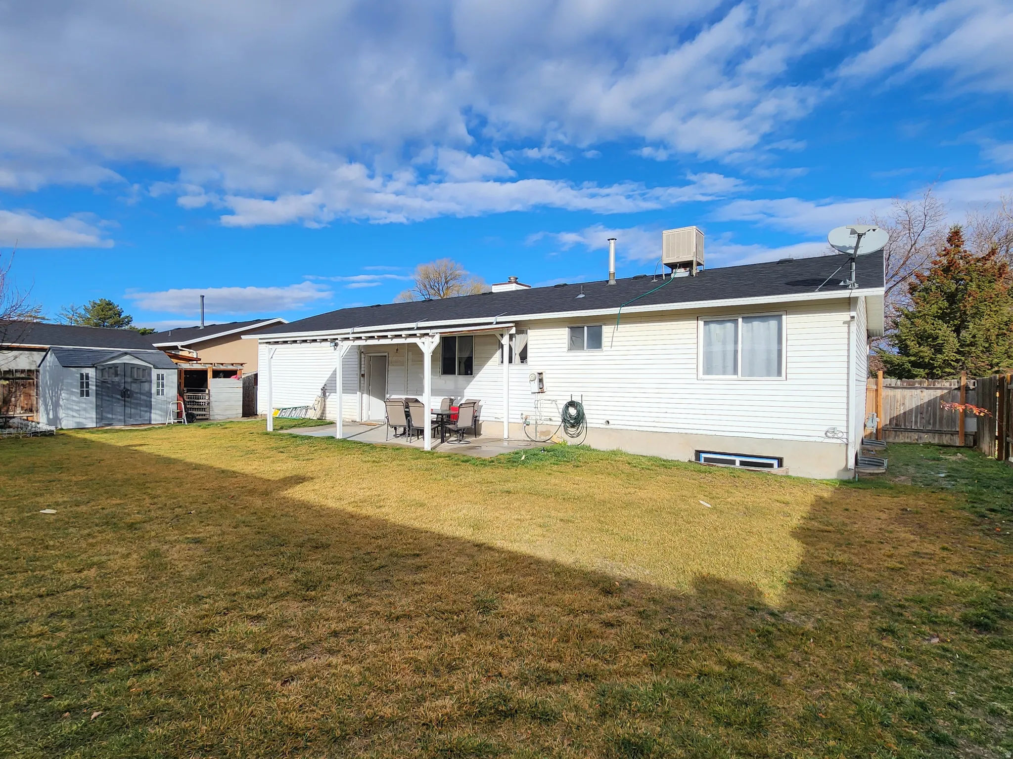 Rear view of property with a patio area and a shed