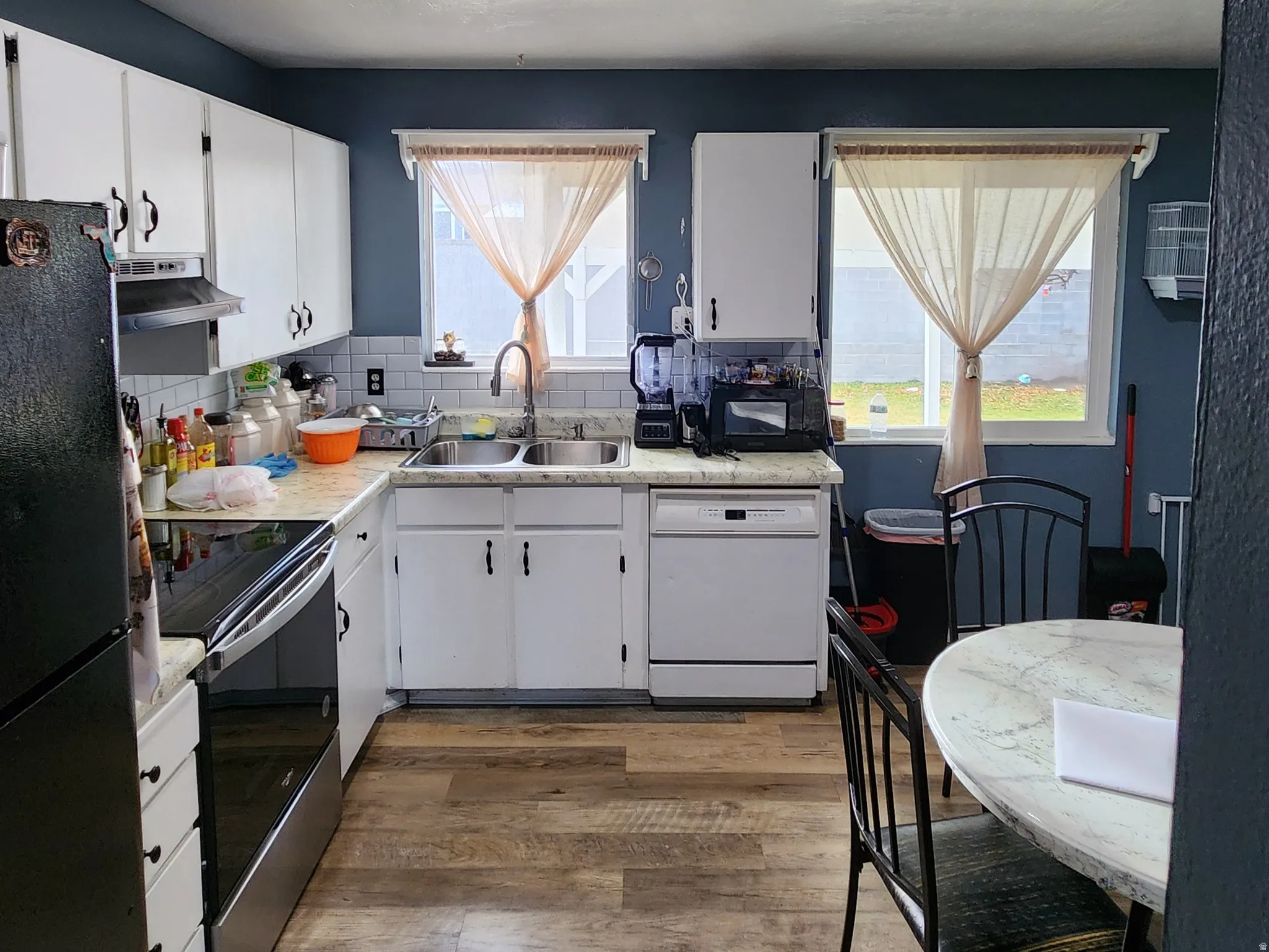 Kitchen with white cabinets, freestanding refrigerator, light countertops, a textured ceiling, and electric stove
