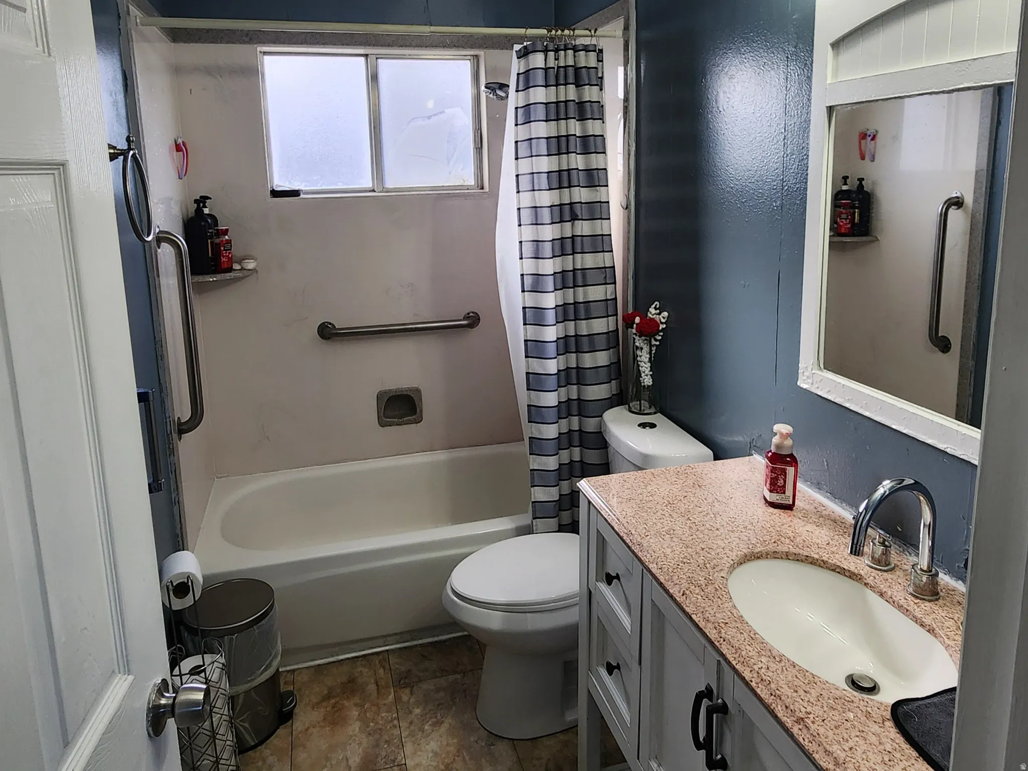 Bathroom with vanity, a textured ceiling, and shower / bathtub combination with curtain