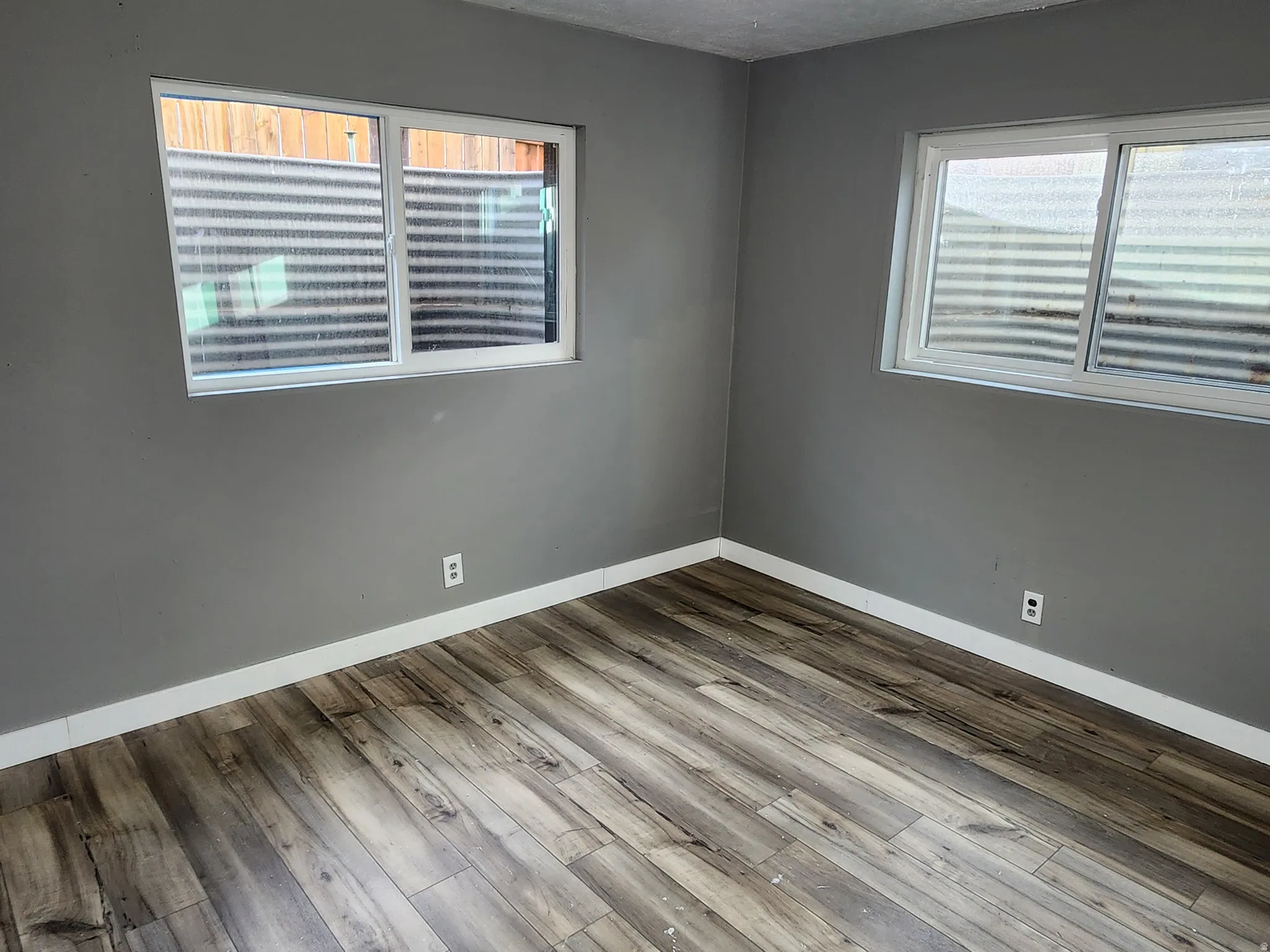 Empty room with a textured ceiling and wood finished floors