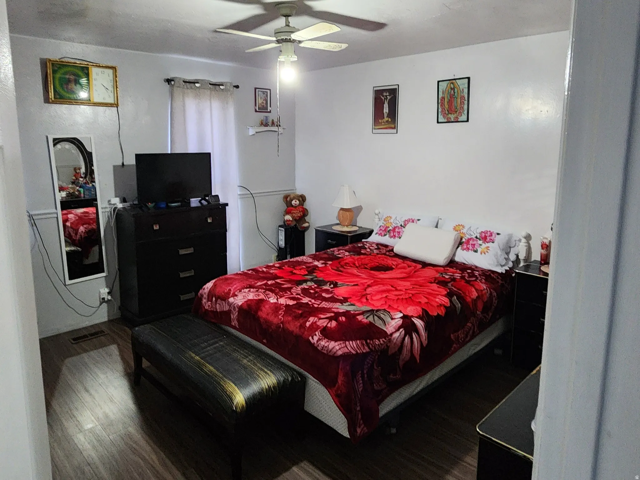 Bedroom with a textured ceiling, a ceiling fan, and wood finished floors