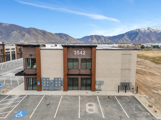 View of building exterior with uncovered parking and a mountain view