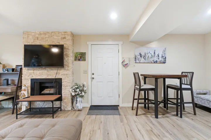 Living area featuring a stone fireplace and light wood-type flooring
