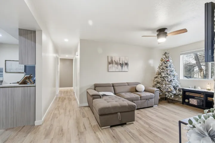 Living room with light wood finished floors and ceiling fan