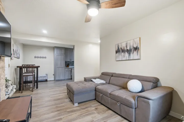 Living area featuring light wood-type flooring, ceiling fan, and recessed lighting