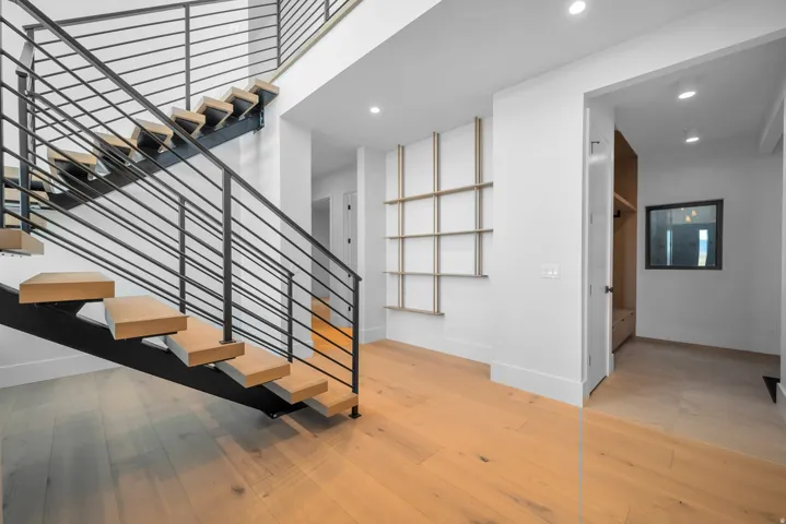 Staircase with hardwood / wood-style floors and recessed lighting