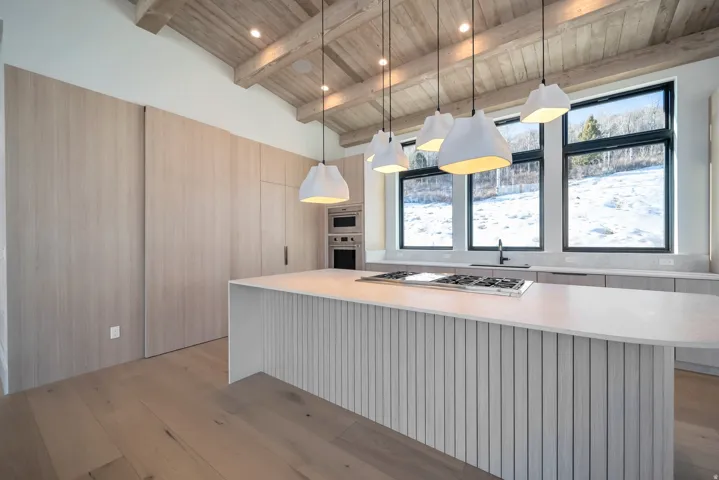 Kitchen with decorative light fixtures, light wood-style floors, appliances with stainless steel finishes, wood ceiling, and a center island