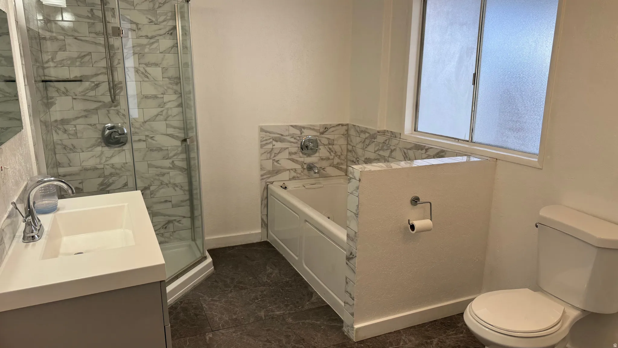 Bathroom featuring a stall shower, a bath, and vanity