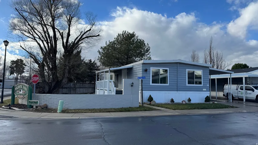 Manufactured / mobile home featuring a fenced front yard and a carport
