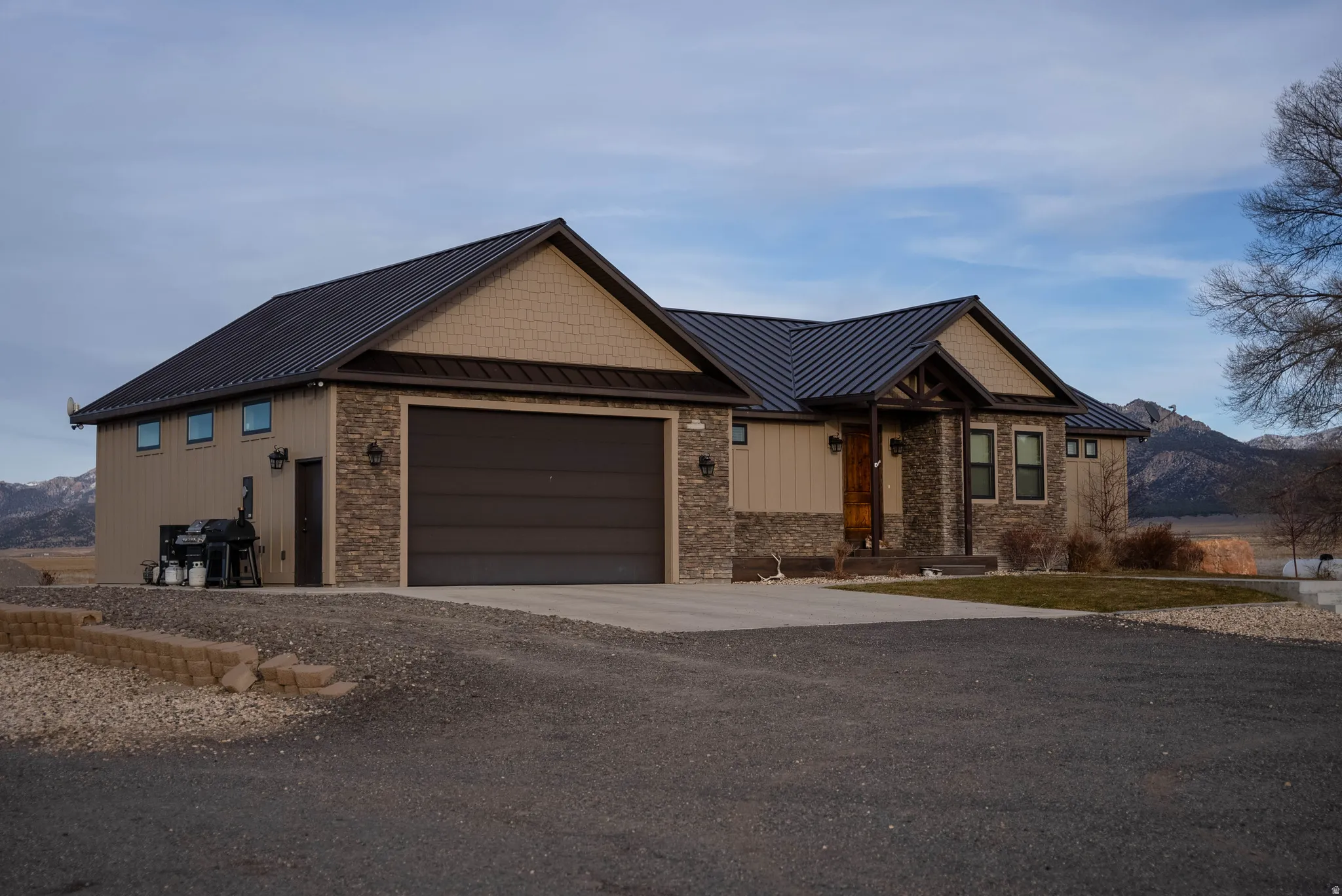 Craftsman-style house with a standing seam roof, a metal roof, a mountain view, an attached garage, and concrete driveway