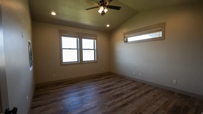 Vaulted ceiling room featuring wood-finish flooring, recessed lighting, and a ceiling fan
