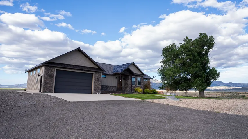 Exterior featuring stone veneer and horizontal siding with a dark metal roof