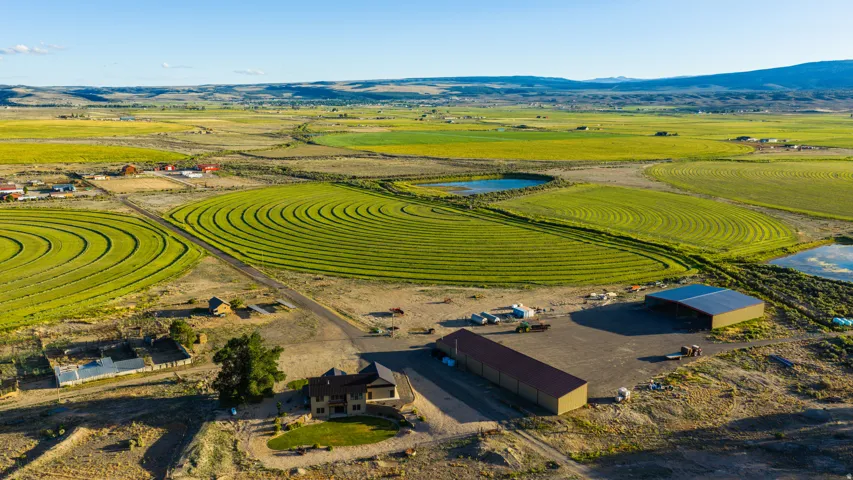 Expansive rural property featuring multiple circular irrigated fields and two distinct outbuildings