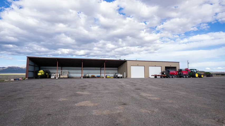 Expansive gravel lot featuring a large metal storage structure with multiple bays