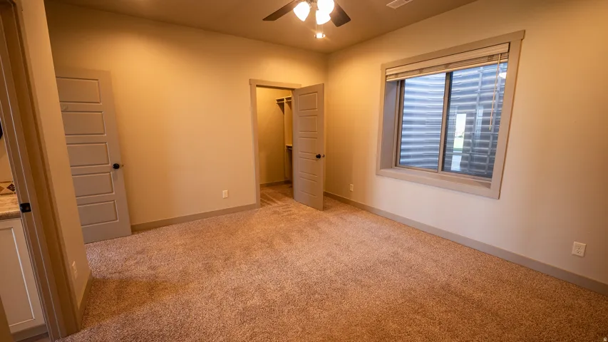 Carpeted room with a ceiling fan, recessed lighting, and a window with blinds