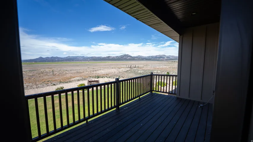Expansive outdoor deck featuring dark composite decking, a sturdy black railing, and a covered ceiling