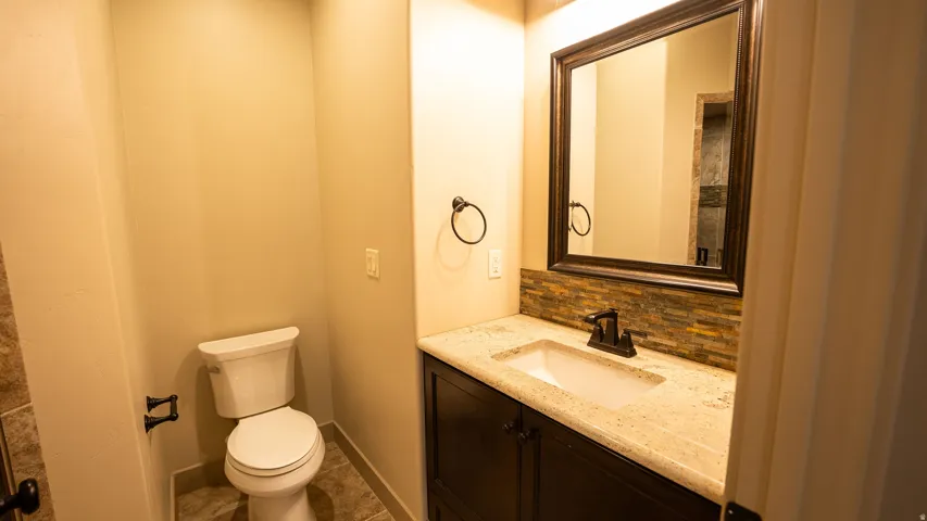 Bathroom featuring a single vanity with a light-toned countertop, dark wood-finish cabinetry, and a rectangular undermount sink