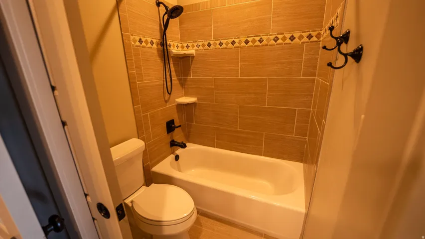 Bathroom featuring a white porcelain tub and a toilet