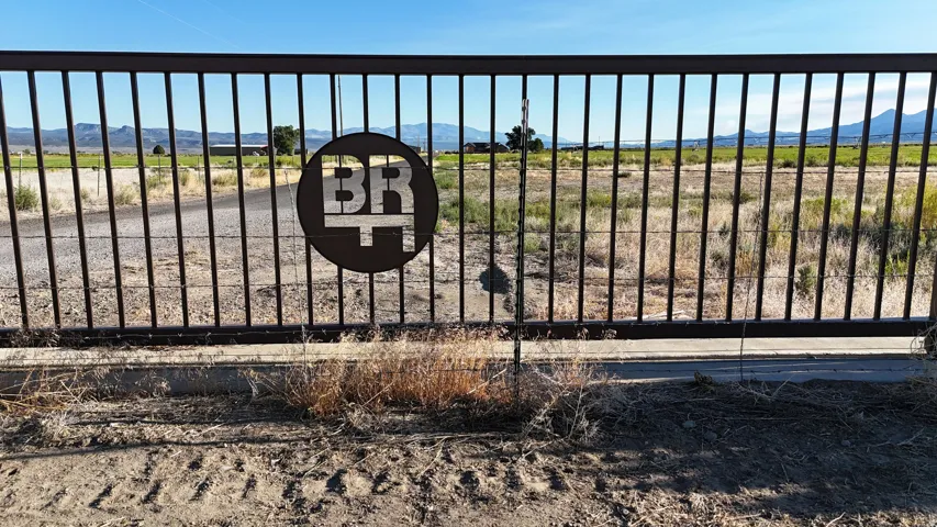 Black metal perimeter gate with a custom circular emblem
