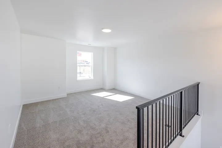 Unfurnished room featuring light colored carpet and baseboards