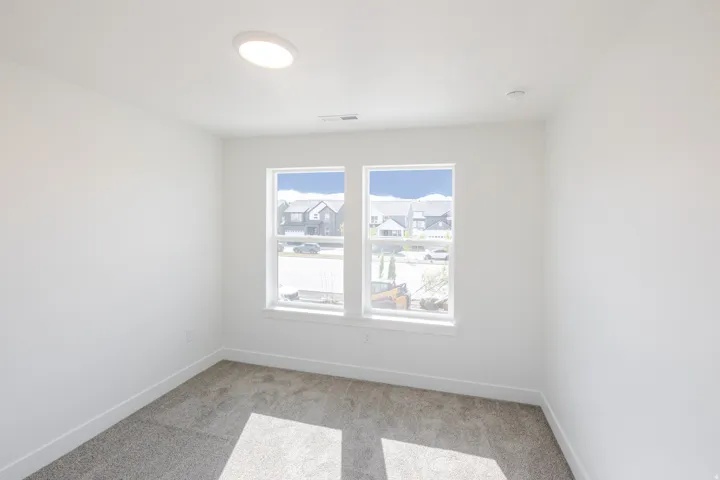 Spare room with light colored carpet and baseboards