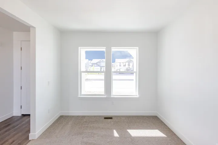 Spare room with light colored carpet and baseboards