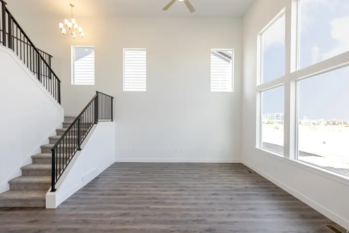 Interior space with a chandelier, dark wood-style flooring, a high ceiling, and a ceiling fan