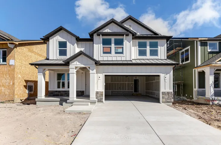 Modern inspired farmhouse with a standing seam roof, covered porch, a garage, board and batten siding, and concrete driveway