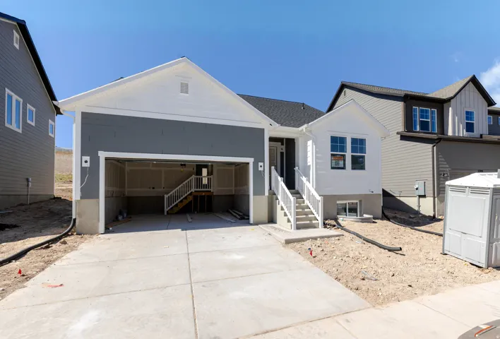 View of front of property featuring concrete driveway and an attached garage