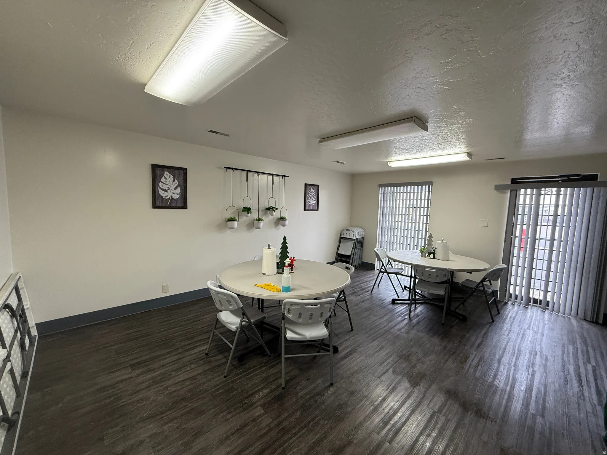 Dining area with a textured ceiling and dark wood-style floors