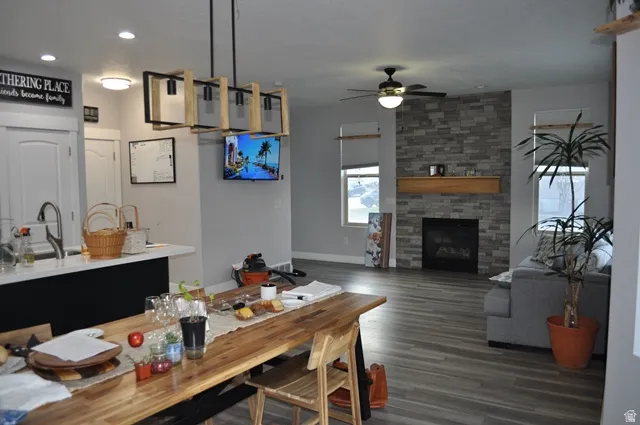 Dining space featuring a fireplace, dark wood-style flooring, ceiling fan, and recessed lighting