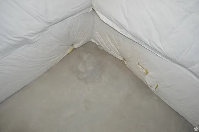 Unfurnished bedroom with unfinished concrete flooring