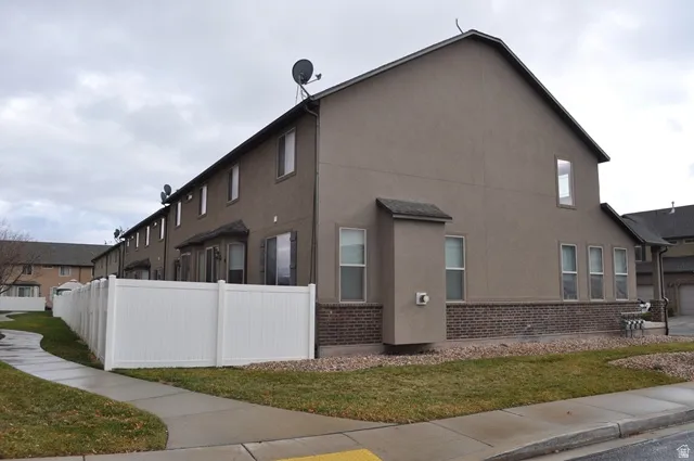 View of property exterior with stucco siding and brick siding