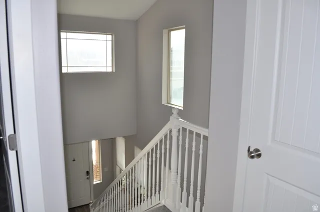 Stairs featuring healthy amount of natural light and a high ceiling