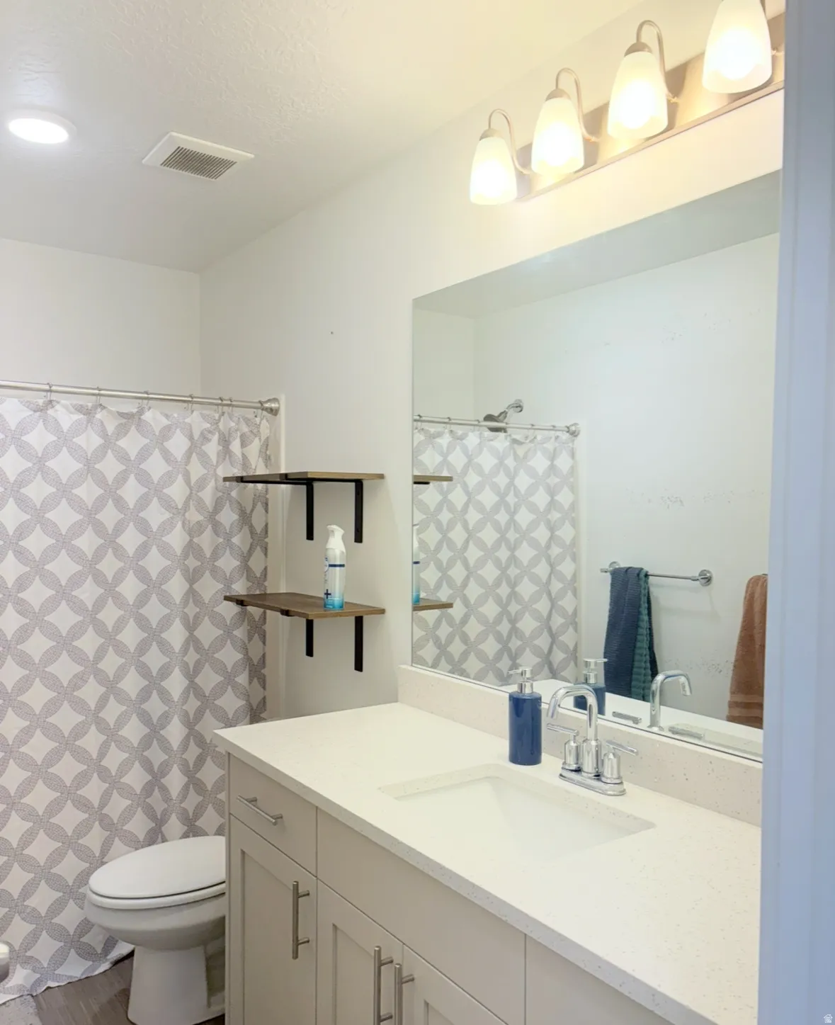 Bathroom with vanity, a shower with curtain, and a textured ceiling