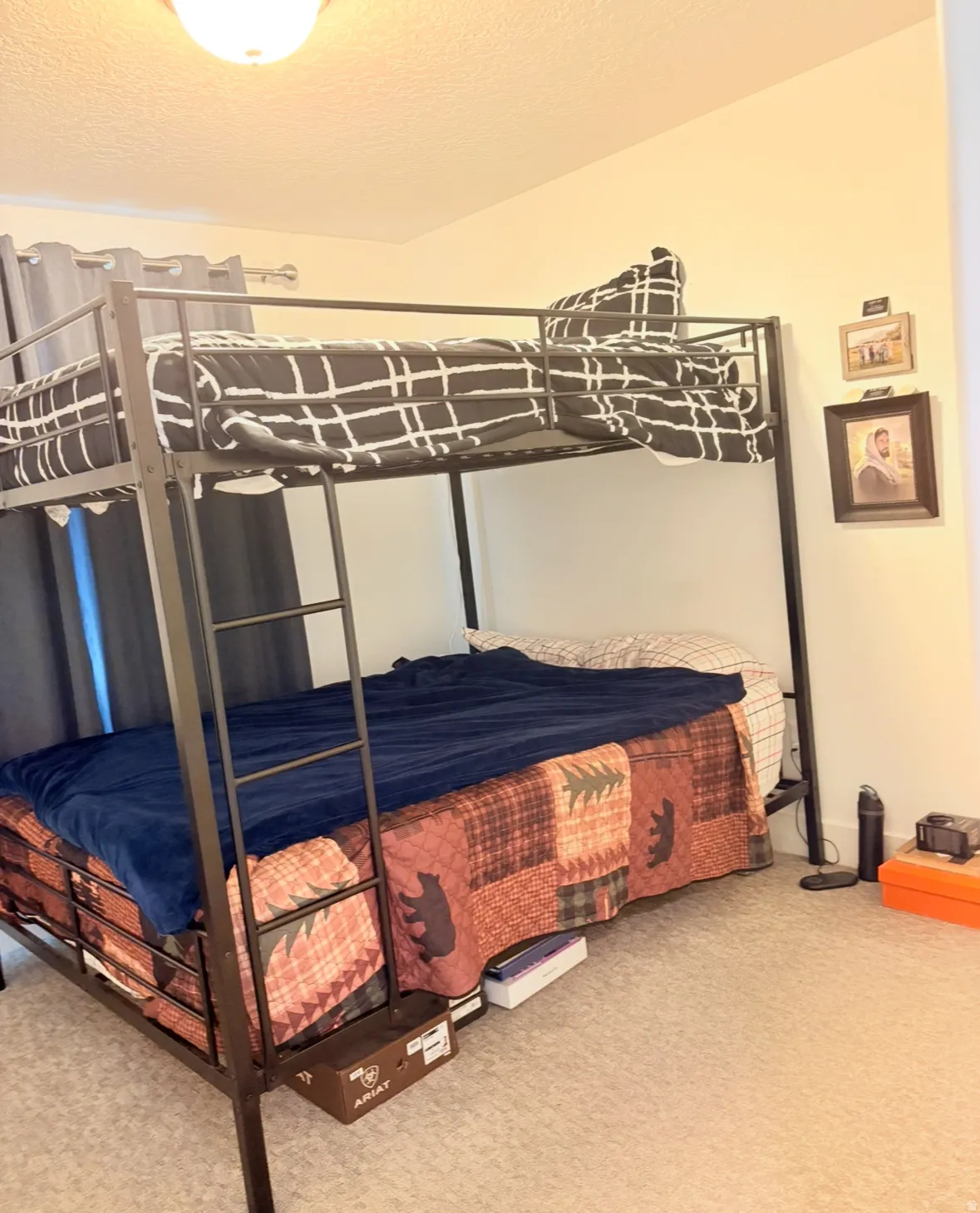 Bedroom with light colored carpet and a textured ceiling